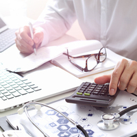 Healthcare costs and fees concept.Hand of smart doctor used a calculator for medical costs in modern hospital