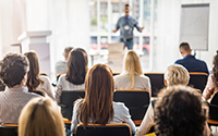 Rear view of business people attending a seminar in board room.