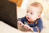 Four,Months,Baby,With,Laptop,At,Home