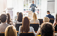 Rear view of business people attending a seminar in board room.