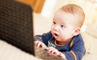 Four,Months,Baby,With,Laptop,At,Home
