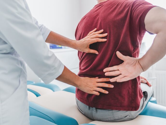 Mann mit Rückenschmerzen beim Arzt