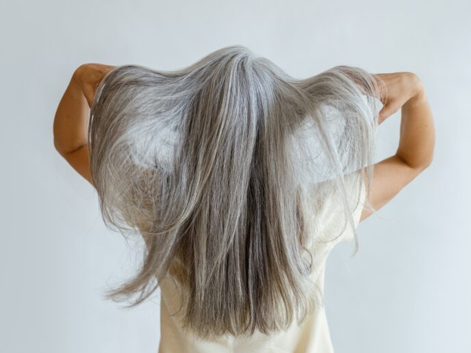 Frau zeigt ihre langen, grauen Haare
