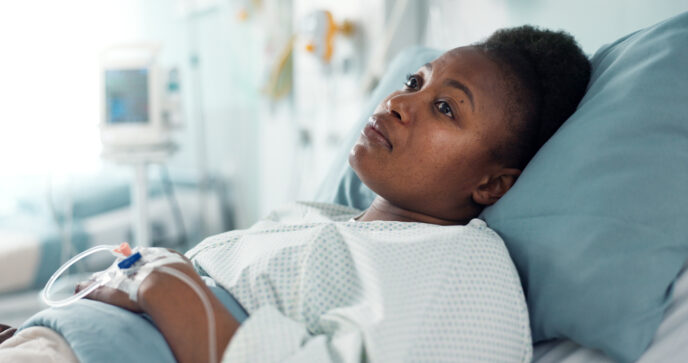 Nachdenkliche Patientin im Krankenhausbett; psychische Belastung und Depression beeinflussen chirurgische Ergebnisse.