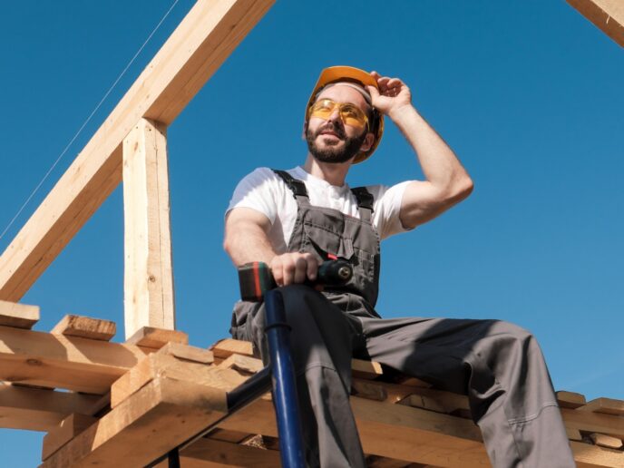 Arbeiter sitz im Sommer in der Sonne auf dem Dachstuhl