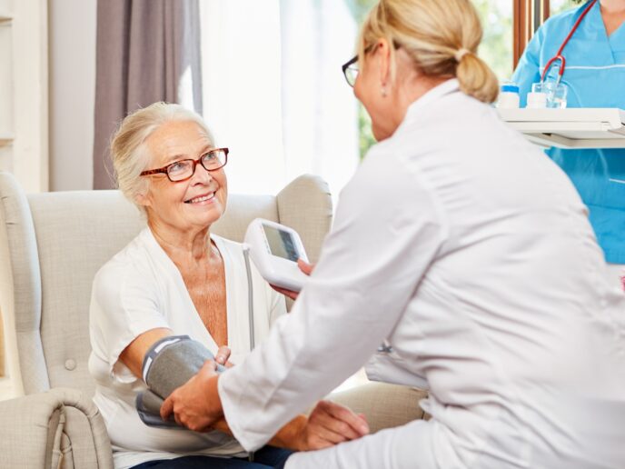 Ärztin misst den Blutdruck bei einer Seniorin