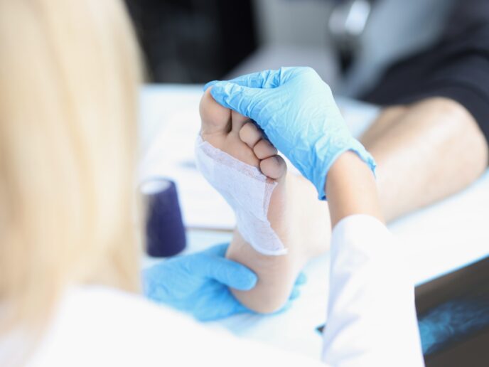 Ärztin versorgt Wunde am Fuß