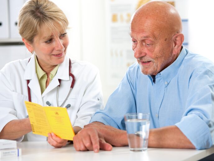 Ärztin berät Senior zu Impfungen