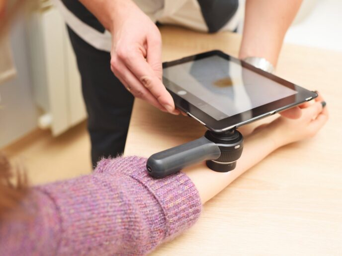 Ärztin untersucht Hautfleck bei einer Patientin