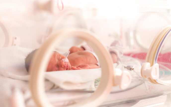 Frühgeborenes Baby liegt in einem Brutkasten